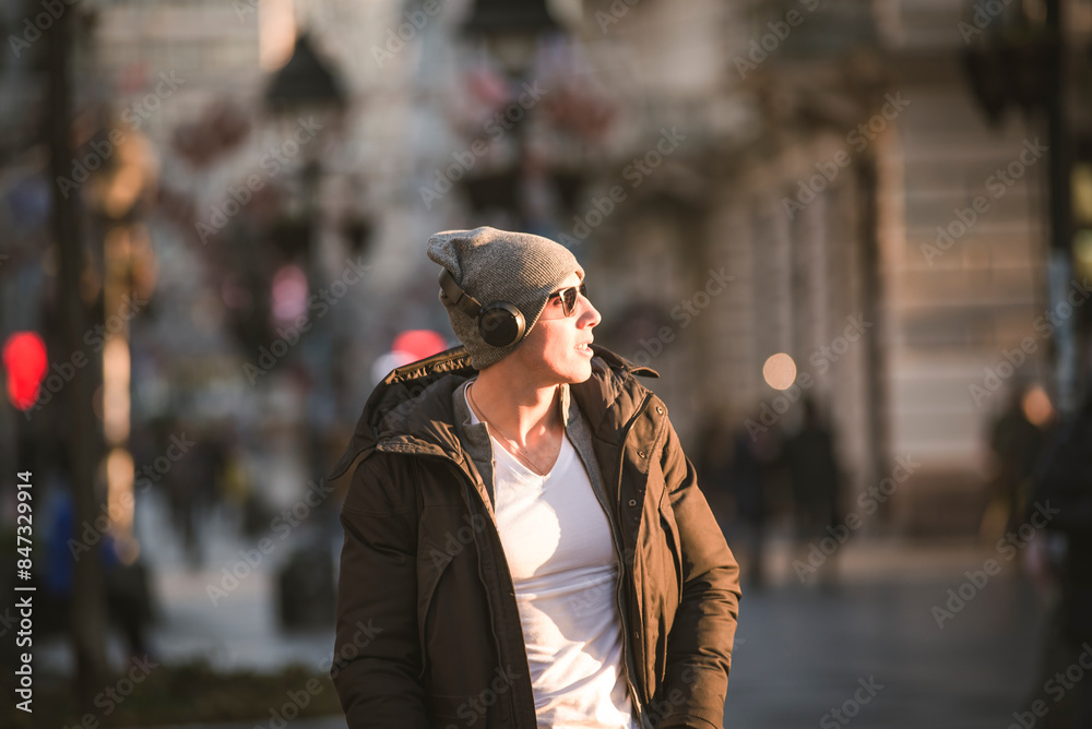 Fototapeta premium Young Man in the Winter City Streets with Headphones