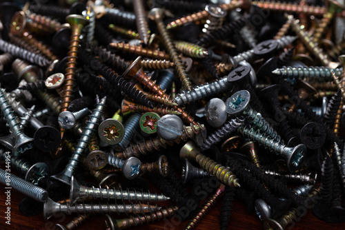 Bunch of different screws on a wooden surface photo