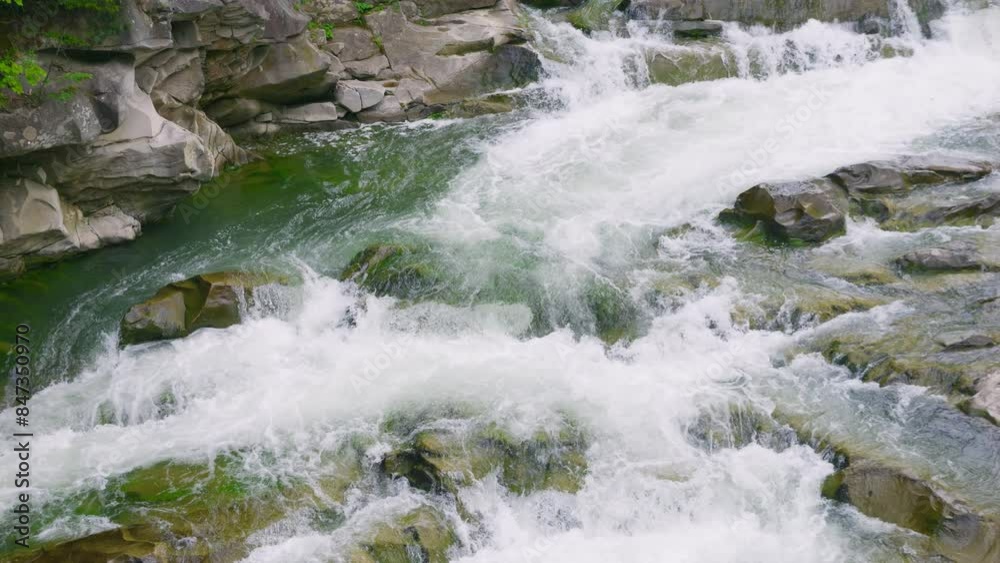 Stormy streams of water and cascades of mountain river waterfalls. Slow motion. Stormy streams of water and cascades of mountain river waterfalls. Slow motion.