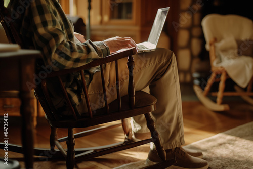 person using a laptop on a rocking chair photo