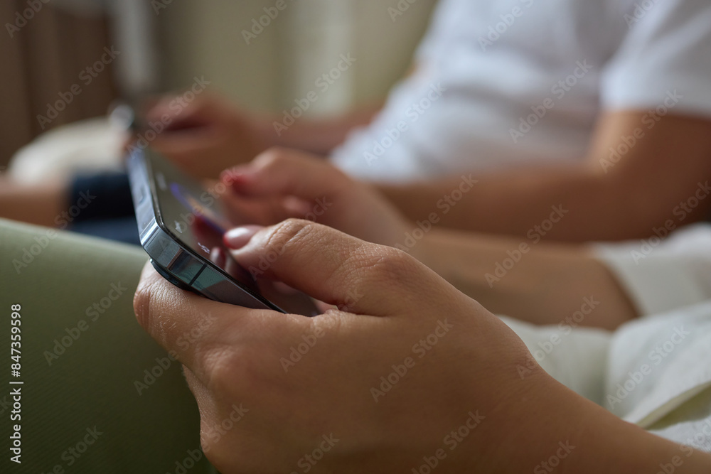 Close-up of a man hands using a phone, He plays a game using mobile internet. Turns the phone vertically. Red light in the evening room Close-up of a man hands using a phone, He plays a game using mobile internet. Turns the phone vertically. Red light in the evening room