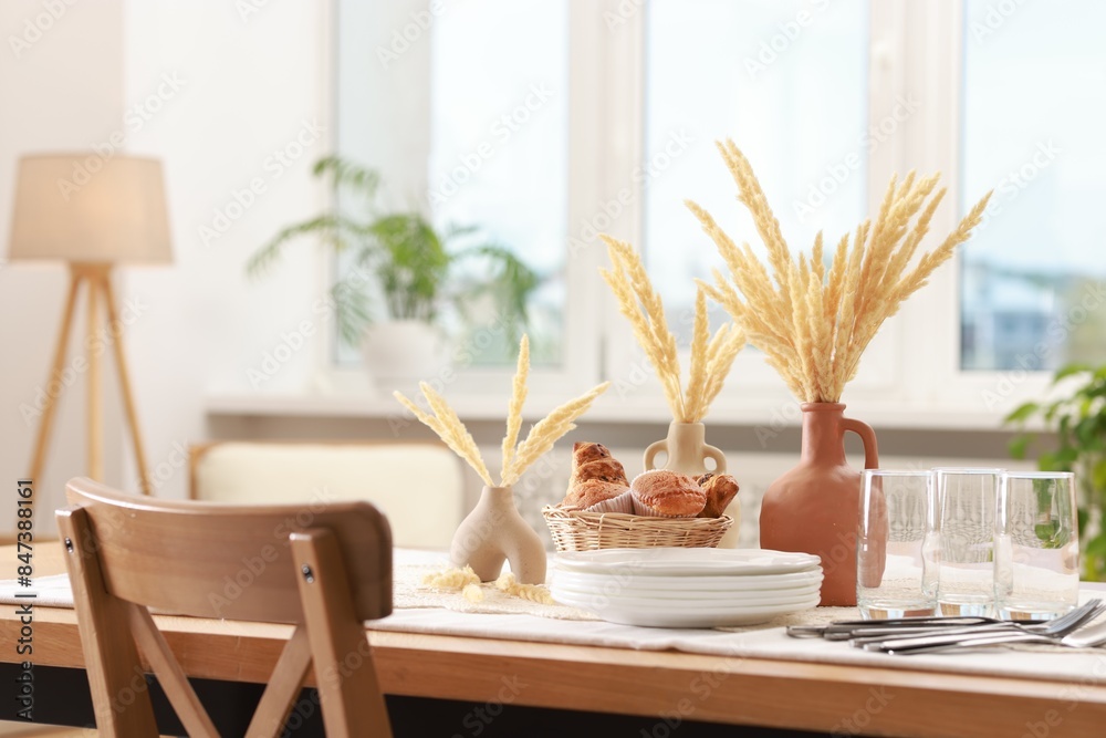 Clean dishes, dry spikes and fresh pastries on table in stylish dining room