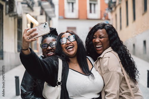 Three happy smiling sisters take a selfie photo