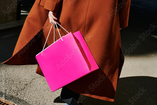 Elegant shopper carrying bright pink bag