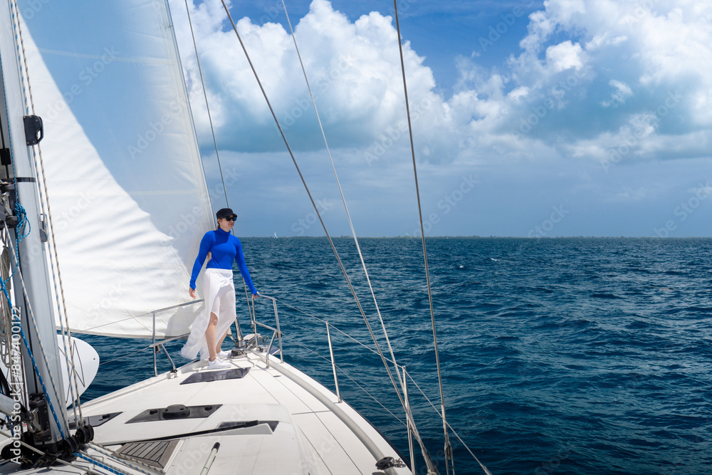 Woman at Bow of Cruising Sailboat on Caribbean Island Vacation Woman at Bow of Cruising Sailboat on Caribbean Island Vacation