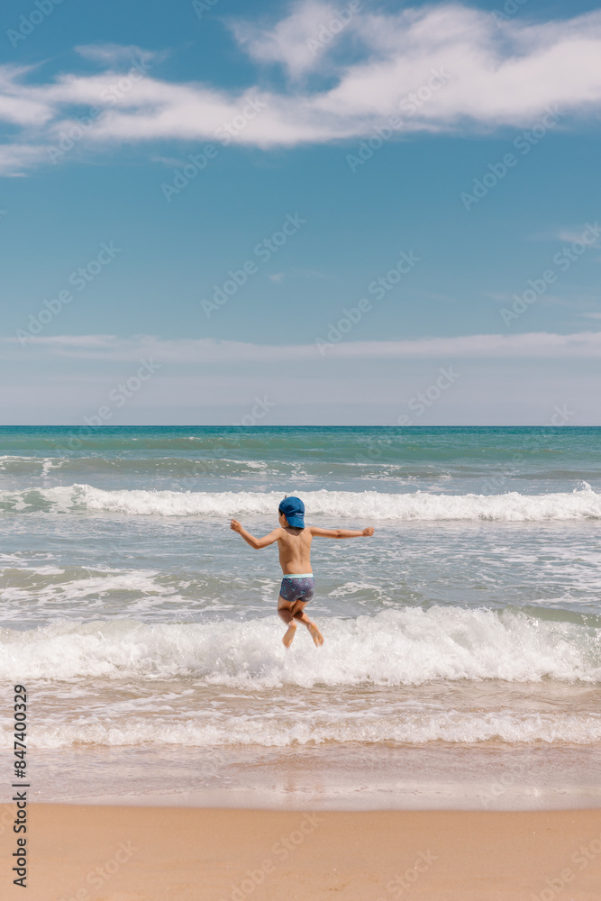 Joyful young boy playing and jumping on the beach Joyful young boy playing and jumping on the beach