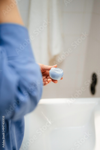 Women's hands with a cosmetic bottle photo