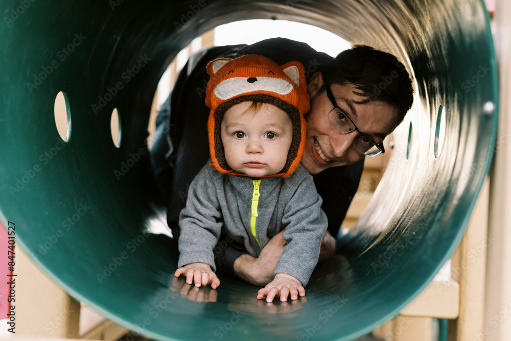 father and infant son playing together at playground father and infant son playing together at playground