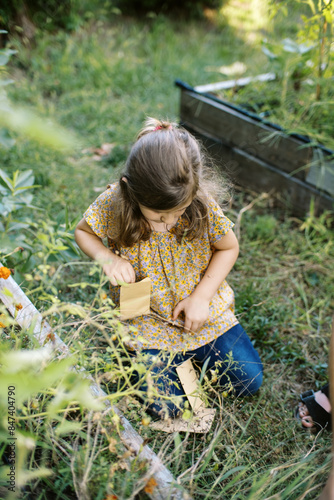 little girl gardening in her backyard in summer photo