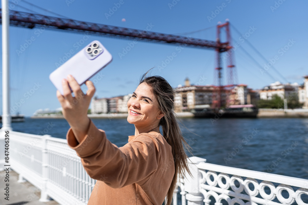 Expectant mother walking by the river taking a selfie Expectant mother walking by the river taking a selfie