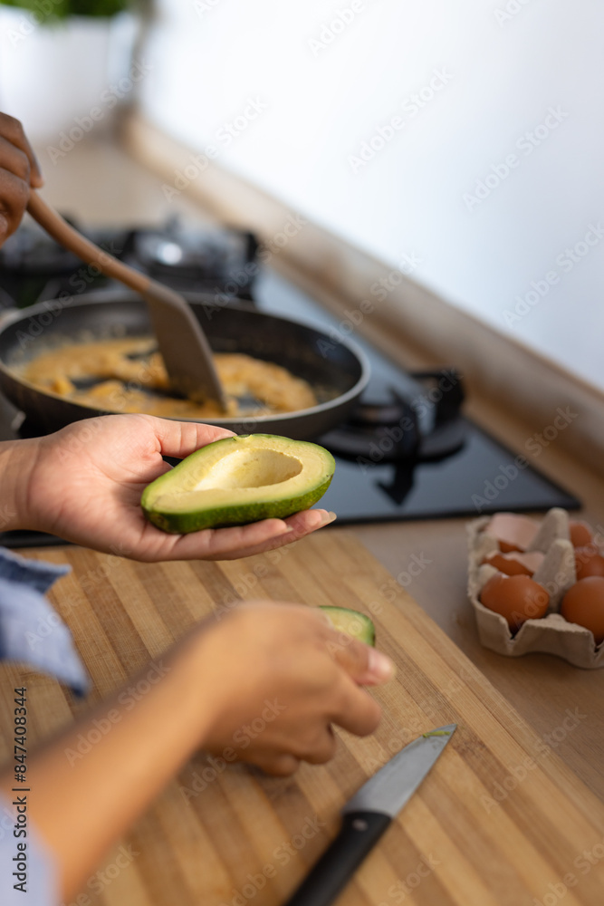 Young diverse couple preparing breakfast with avocados together in their kitchen Young diverse couple preparing breakfast with avocados together in their kitchen