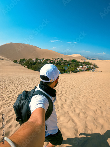 viajero de espaldas tomando una foto en el desierto de hucachina