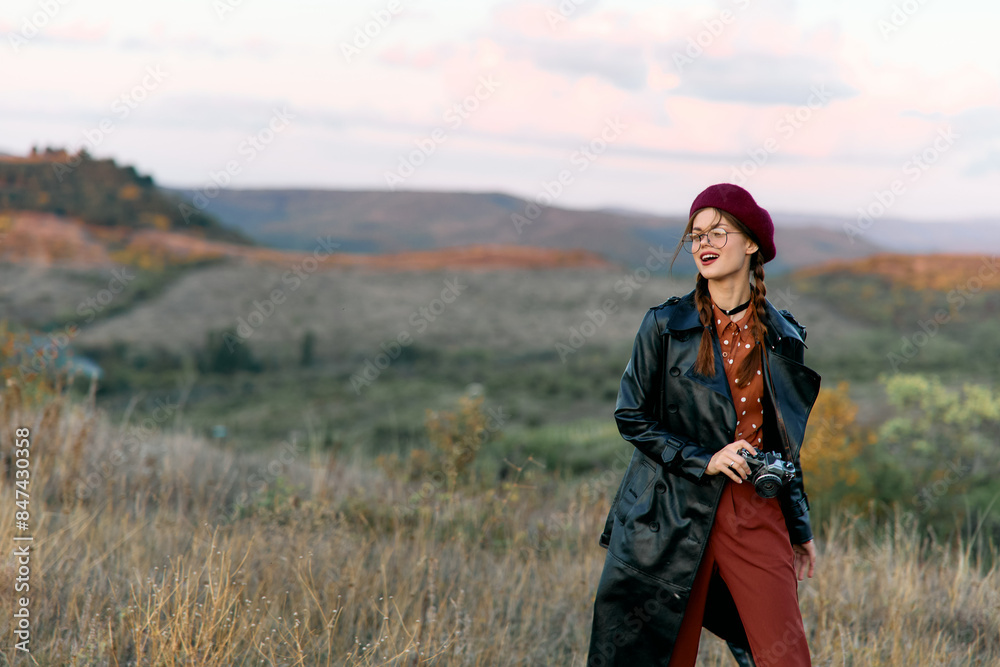 Woman in black coat and red pants standing confidently in vast field under open sky Woman in black coat and red pants standing confidently in vast field under open sky