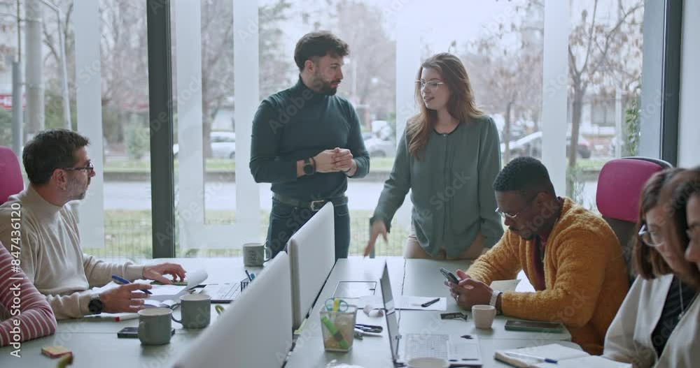 A different aged group of business associates collaborates in a well-lit office environment, sharing ideas and strategies during a dynamic brainstorming session.