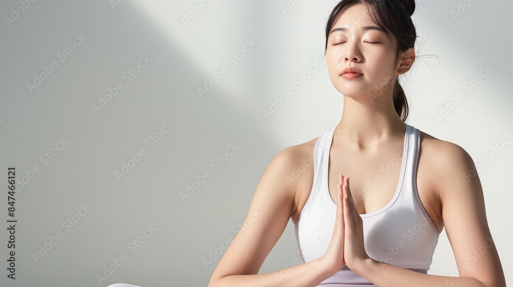 Fototapeta premium Woman in a does yoga with her hands folded in a prayer position. Peace and tranquility and harmony with oneself