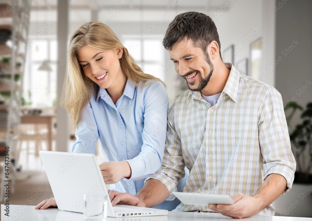 Obraz premium Happy young couple with laptop relaxing at home.