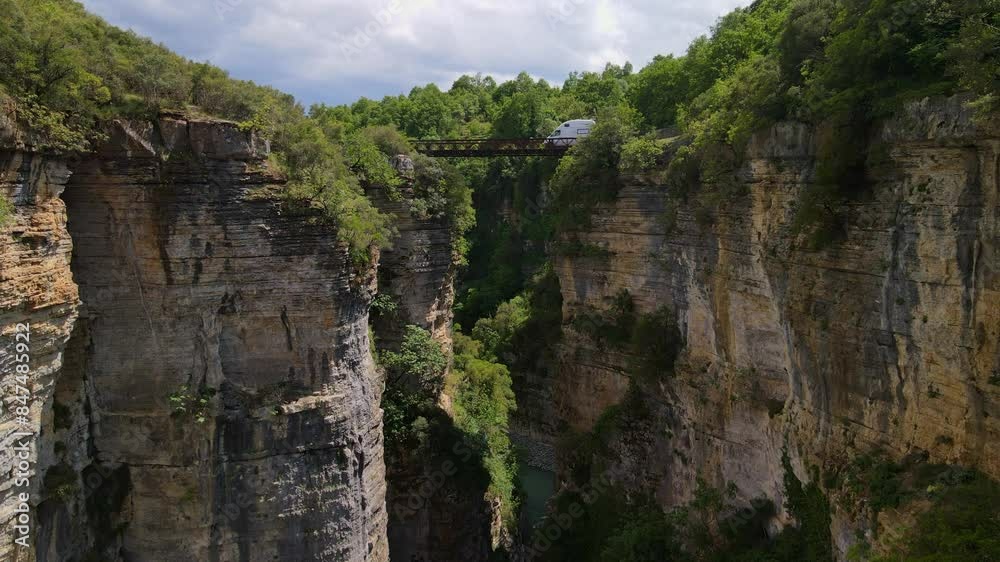 Osum Canyon with a bridge over which a motorhome drives. Wild rocky nature of Albania with green vegetation Osum Canyon with a bridge over which a motorhome drives. Wild rocky nature of Albania with green vegetation