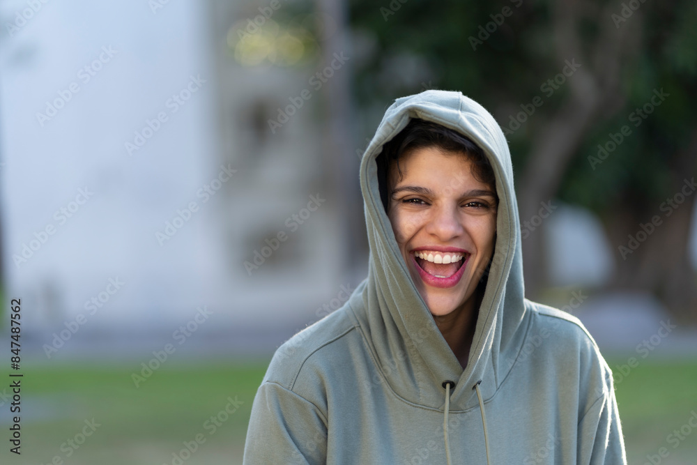Woman with short hair and masculine appearance wearing a hoodie smiling Woman with short hair and masculine appearance wearing a hoodie smiling