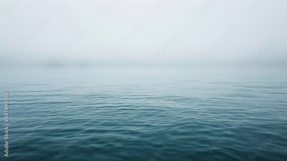 Calm body of water with a foggy sky in the background