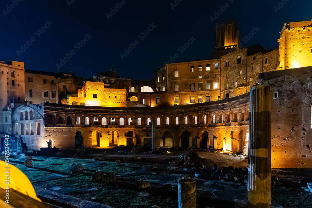 Obraz premium Rome, Italy - April 09, 2024: Night view of the ruins of the Roman Forum in Rome with tourists crowding its surroundings in Rome, Italy