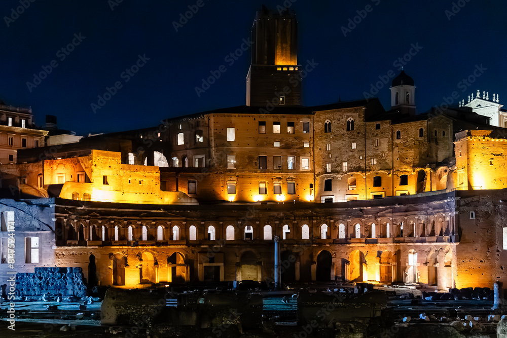 Rome, Italy - April 09, 2024: Night view of the ruins of the Roman Forum in Rome with tourists crowding its surroundings in Rome, Italy Rome, Italy - April 09, 2024: Night view of the ruins of the Roman Forum in Rome with tourists crowding its surroundings in Rome, Italy