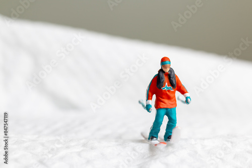 A miniature figurine of a skier dressed in vibrant winter gear. This image is perfect for themes related to winter sports