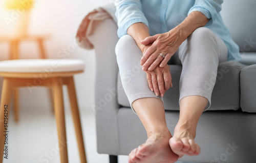 An elderly woman holding her knees with the pain of wellness health care or problem concept