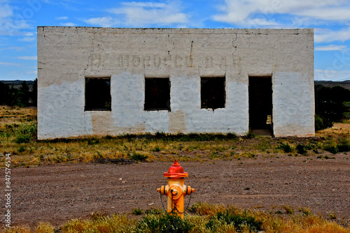 Colorful fire hydrant and black and white building. Diego Tafoya built the El Morocco Bar In the 1930-40’s ??? It still stands on Polvadera Road now a frontage to US Hwy 85, Polvadera, New Mexico  photo