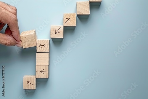 Someone is arranging wooden blocks with upwardpointing arrows