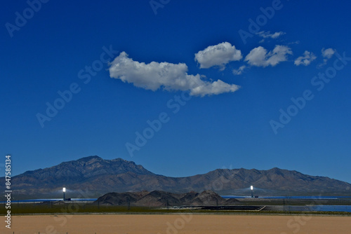 Distant view to Bright solar furnaces glowing on Ivanpah Valley with the Clarke Mountains in the background. Mojave Desert, California  photo