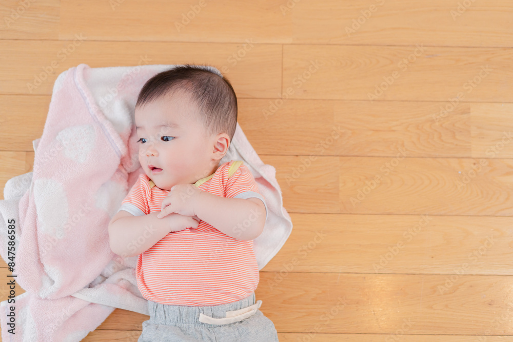 おうちの床に寝転がる赤ちゃん おうちの床に寝転がる赤ちゃん
