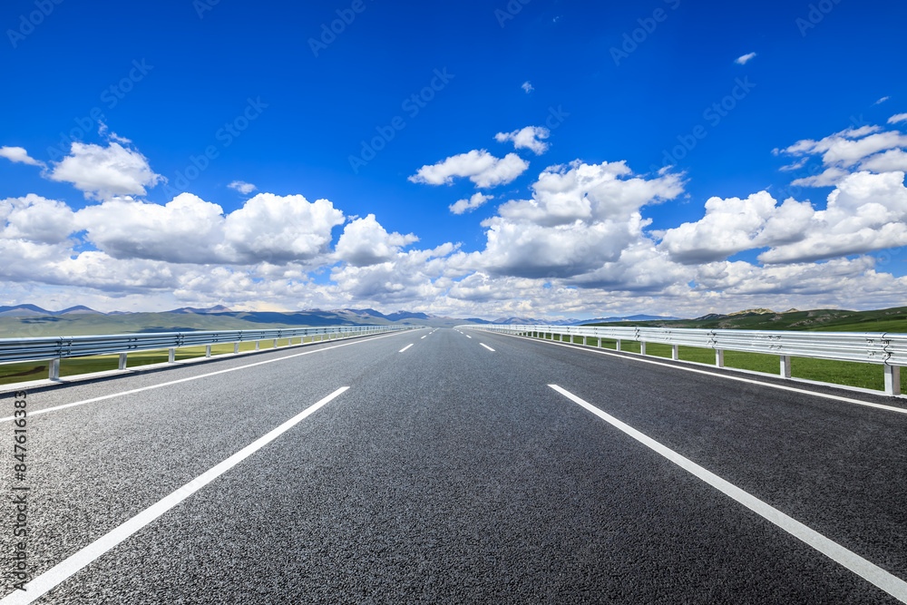 Straight asphalt highway and mountains with sky clouds background Straight asphalt highway and mountains with sky clouds background