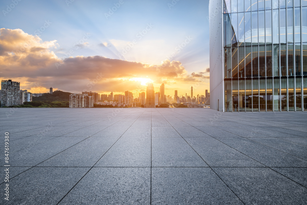 Empty square floor and glass wall with modern city buildings scenery at sunrise Empty square floor and glass wall with modern city buildings scenery at sunrise