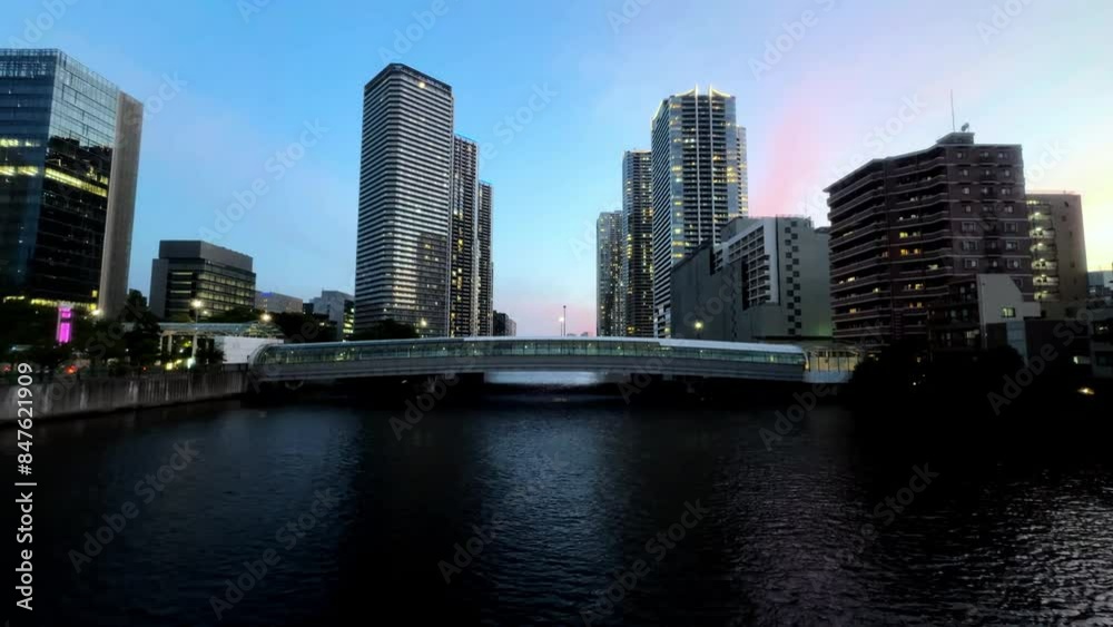 Cityscape at twilight with high-rise buildings and a river bridge, urban evening scene Cityscape at twilight with high-rise buildings and a river bridge, urban evening scene