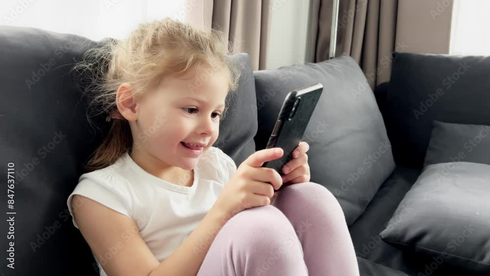 Girl sitting on a sofa at home and using a smart phone Girl sitting on a sofa at home and using a smart phone