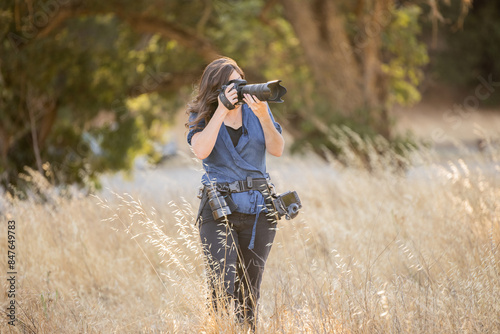 Women taking photos in tall brown grass standing photo