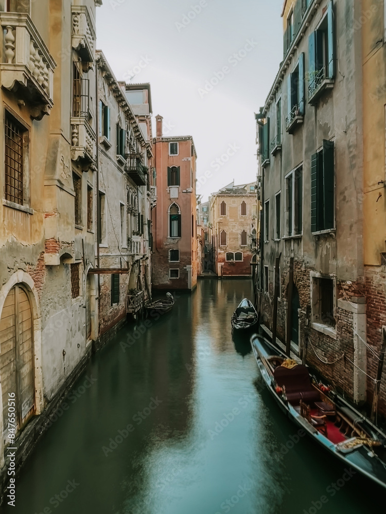 View of buildings and boats on quiet narrow canal in Venice, Italy. View of buildings and boats on quiet narrow canal in Venice, Italy.