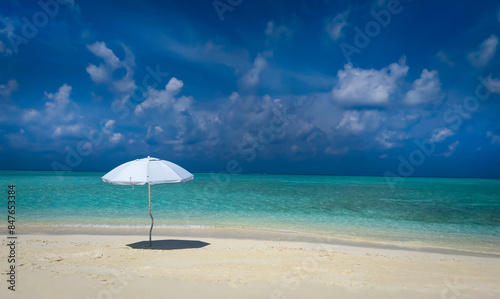 Summer tropical with white umbrella on the beach with blue sky background