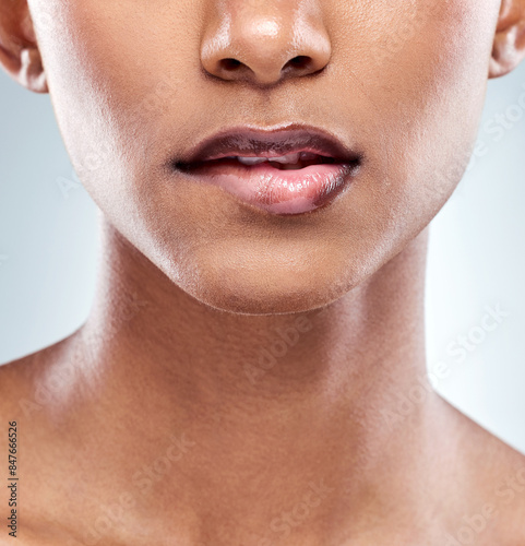 Skincare, woman and face biting lip in closeup for beauty and dermatology isolated in studio. Mouth, female person or model and luxury spa treatment for cosmetics and makeup with white backdrop