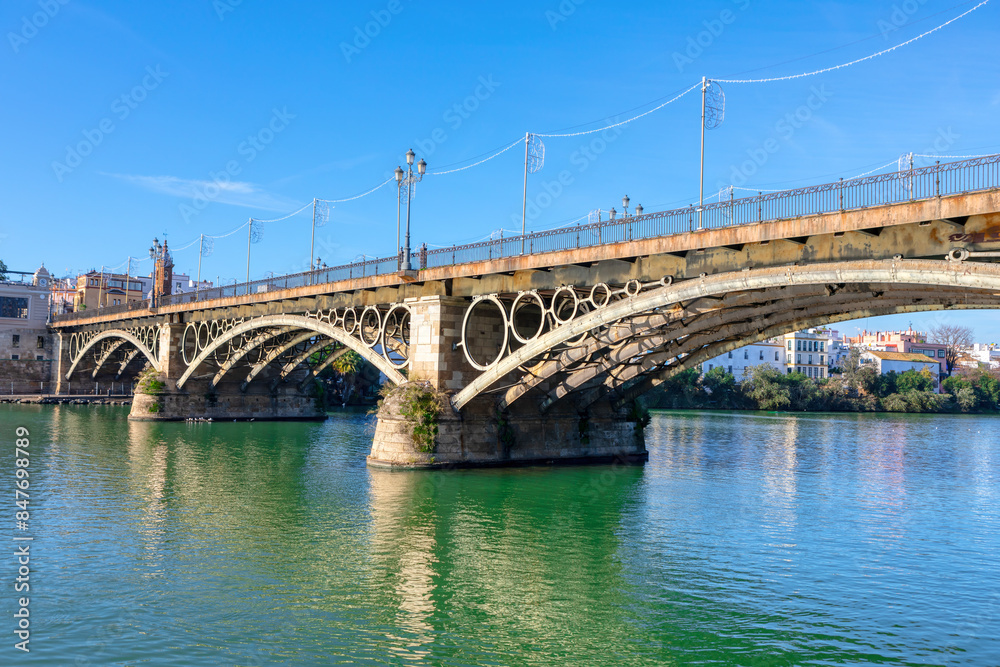 Puente de Triana in Seville Spain. Iron arch bridge connecting the Triana neighborhood to Seville center Puente de Triana in Seville Spain. Iron arch bridge connecting the Triana neighborhood to Seville center