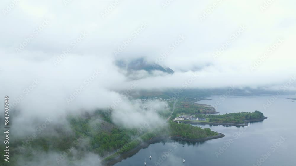 Misty aerial view of Glencoe in Scotland with clouds covering the lush landscape and serene lake Misty aerial view of Glencoe in Scotland with clouds covering the lush landscape and serene lake