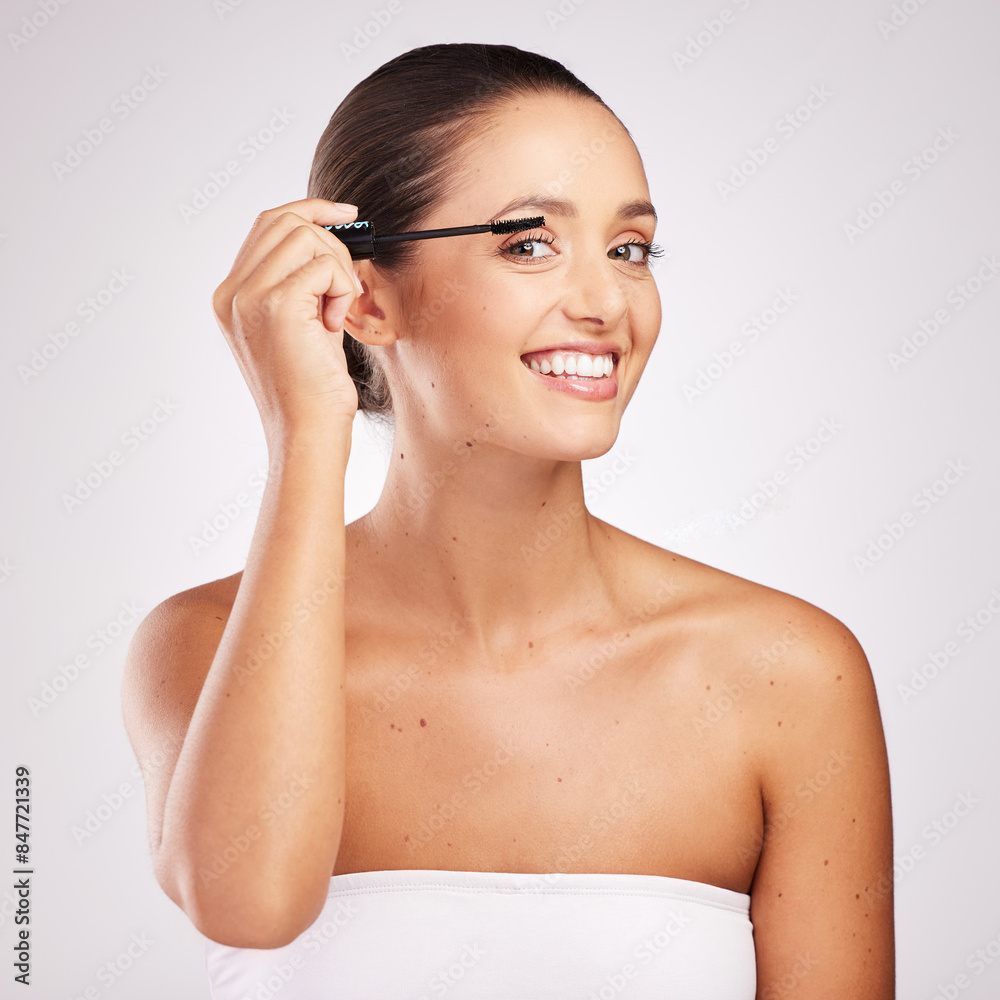 Woman, mascara and beauty portrait with brush for application, volume results and wellness in studio. Female person, smile and makeup tool for eyelash extension and transformation by white background Woman, mascara and beauty portrait with brush for application, volume results and wellness in studio. Female person, smile and makeup tool for eyelash extension and transformation by white background