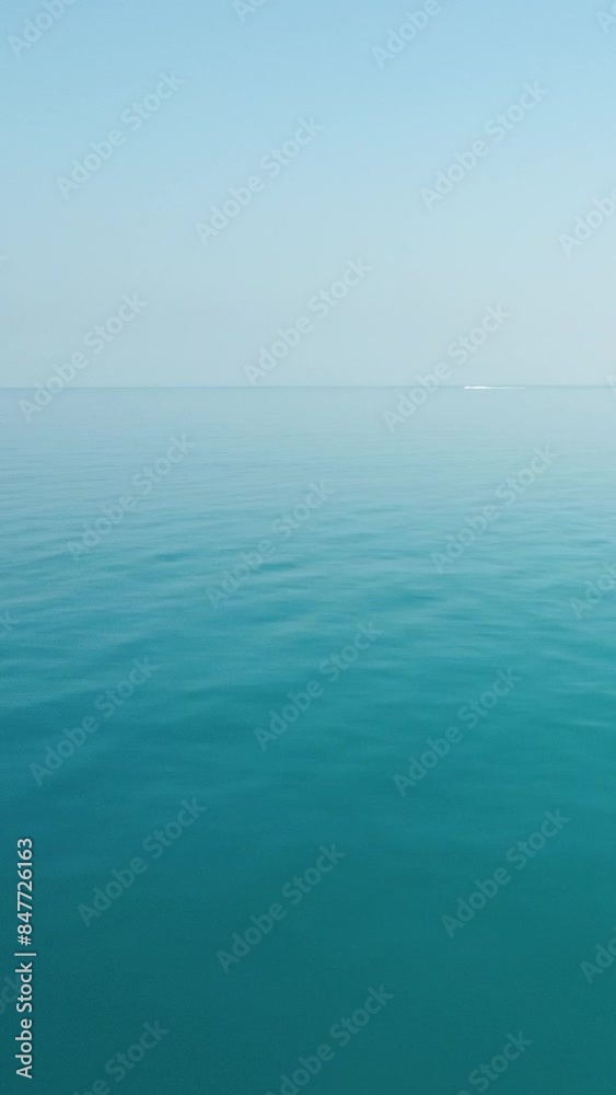 Aerial vertical view on calm azure sea. Small waves on water surface in motion blur. Nature summer ocean sea beach. Nobody. Weather and climate change. Holiday, vacation and travel idea. Aerial vertical view on calm azure sea. Small waves on water surface in motion blur. Nature summer ocean sea beach. Nobody. Weather and climate change. Holiday, vacation and travel idea.