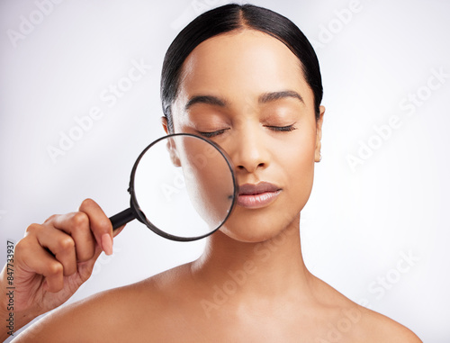 Skincare, woman and magnifying glass for beauty with confidence, pride for dermatology on white background. Female person, cosmetic and results with eyes closed, face in studio for wellness or glow