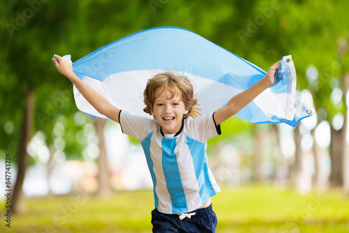 Child running with Argentina flag. Argentinian fan