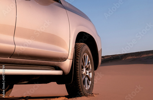 Close up of a golden car stuck in the sand in the Namib desert. 