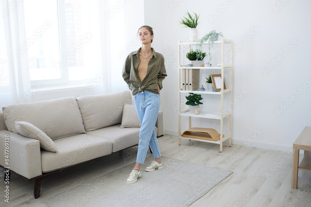 Joyful Jump: A Playful Lady Dancing in a Relaxing Apartment with a Smile and Music on a Sofa Joyful Jump: A Playful Lady Dancing in a Relaxing Apartment with a Smile and Music on a Sofa