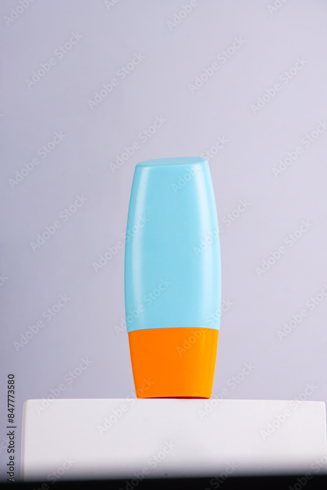 Blue cosmetic bottle, Skin care or sunscreen cosmetic with stylish props on white background.