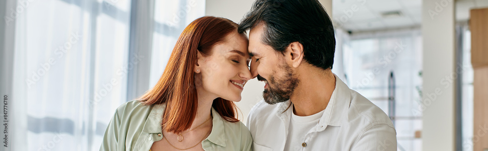 A beautiful adult couple, a redhead woman, and a bearded man are embracing each other in an office setting, expressing love and connection. A beautiful adult couple, a redhead woman, and a bearded man are embracing each other in an office setting, expressing love and connection.