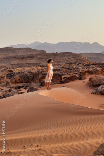 girl looking the horizon on red dune sand in wadi rum desert photo